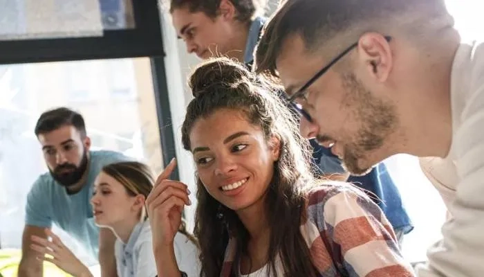 Woman and man smiling and looking at laptop